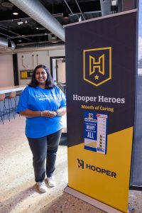 Raj Ravi wearing a United Way t-shirt standing next to a Hooper banner